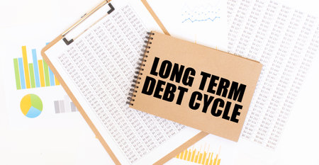 Text LONG TERM DEBT CYCLE on brown paper notepad on the table with diagram. Business conceptの写真素材