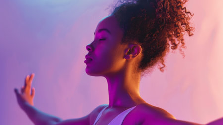 Tranquil woman meditating with vibrant lighting. Studio portrait with colorful gradient background.の素材