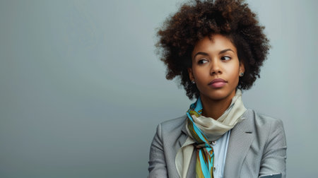 Thoughtful African American businesswoman in a smart gray suit. Corporate confidence and empowerment concept.の素材