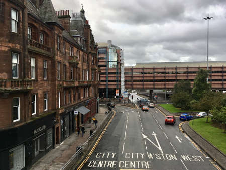 Glasgow Scotland UK - August 19 2017: Street scene with roads almost free of any traffic, heading into the center of the city of Glasgow, with large building in the left side, during cloudy dayのeditorial素材