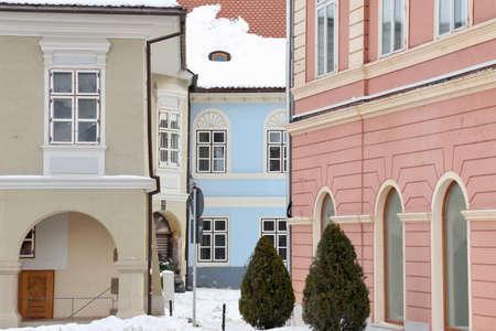 Brasov, Romania - January 15 2017: Cropped view of the pastel colored facades of the old buildings in the Sfatului Square in the center of the Brasov city in Transylvania Romania, during winterのeditorial素材