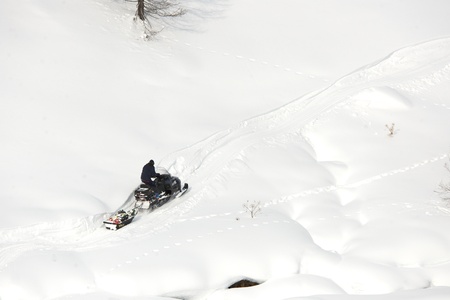 man riding on a snowmobile in a sunny dayの写真素材