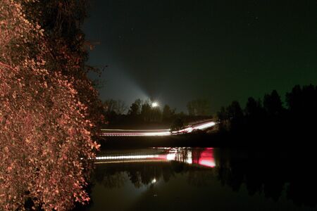Driving a car on a night road in the forestの写真素材