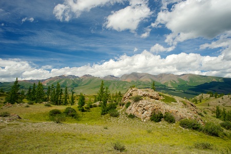 Beautiful sunny valley between the mountains with lush clouds in the Altai Republic