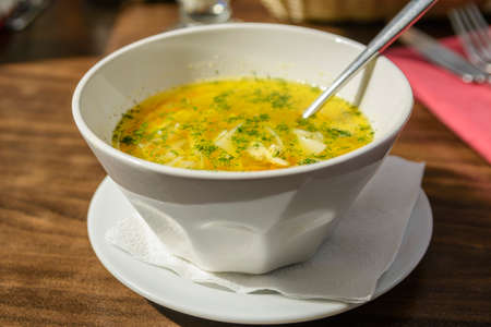 full bowl of soup with a spoonの写真素材