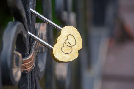 lock on a bridge in the shape of heartの写真素材