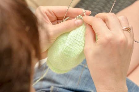 Knitting with needles woolen products female hands