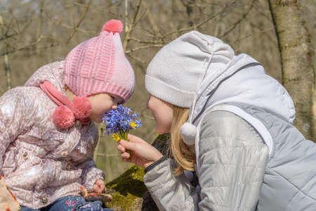 Girl with a bouquet of wild flowers in the forestの写真素材
