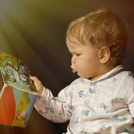 child reading a book in the rays
