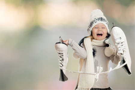 The little girl holds skates and rejoicesの写真素材