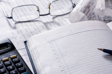 notebook pen glasses checks are on the tableの写真素材