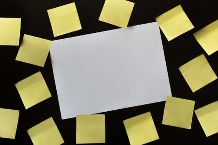 Stickers yellow and a large sheet of paper on a black background
