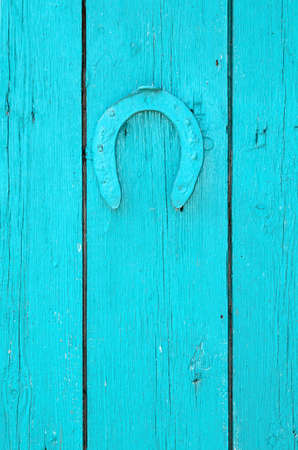 Horseshoe hangs on a wooden painted surfaceの写真素材