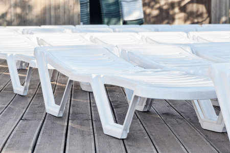 Many chaise lounges in a row
