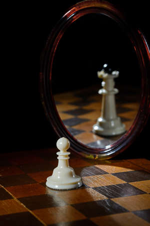 the reflection in the mirror of a chess Queen and pawnの写真素材