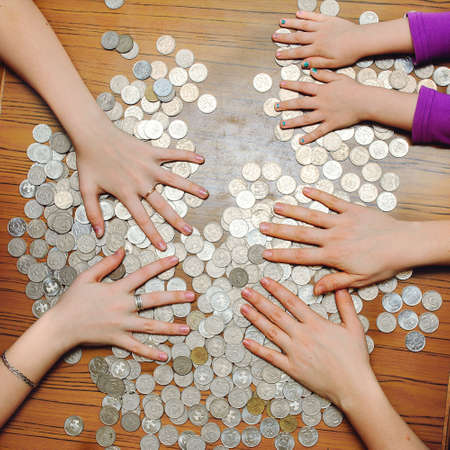 money scattered on the table and a lot of handsの写真素材