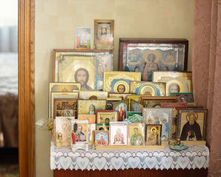 icons of saints are on the bedside table in the roomの写真素材