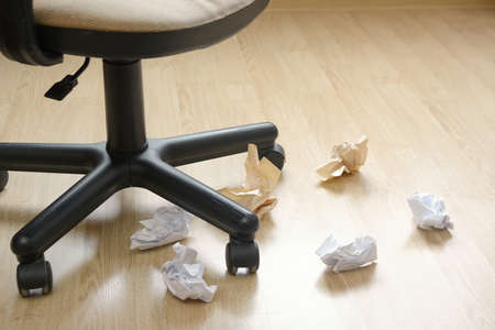 office chair crumpled paper on floorの写真素材