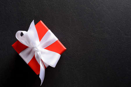 gift red box with white ribbon tied on a bow