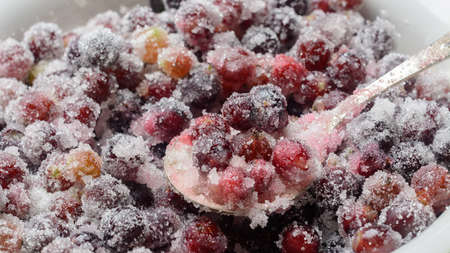 the process of making jam from gooseberries and currants covered with sugarの写真素材
