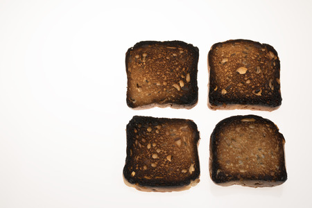 Burned bread with seeds isolated on white backgroundの写真素材