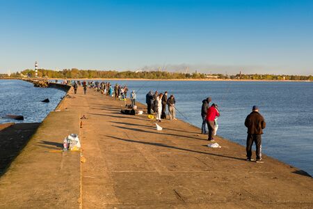 LATVIJA,RIGA - May 5,05,2018:Fishermen catch Baltic herring with fishing rods on the pier in Gulf of Rigaのeditorial素材