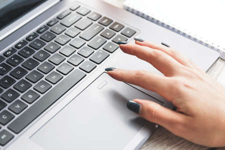 Young woman unlocking her laptop by fingerprint scanner.の写真素材