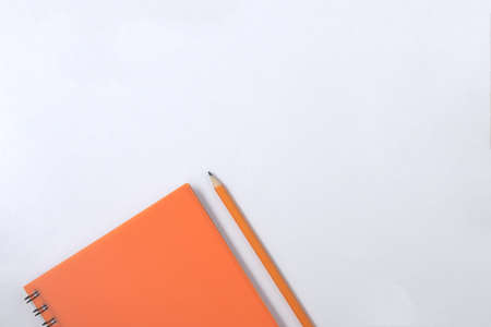 Design concept - Top view of orange spiral notebook and color pencil collection on white backgroundの写真素材