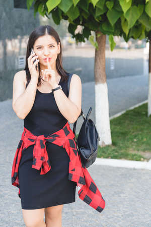 Attractive brunette businesswoman talking on mobile phone with client in the streetの写真素材