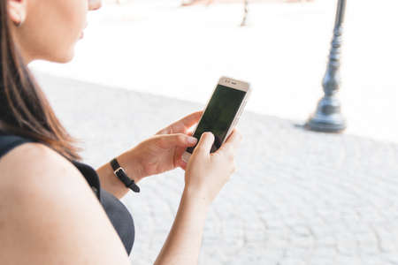 Close up of hands using modern smart phone, sunny day, sunlight, she chatting with friends at social networkの写真素材