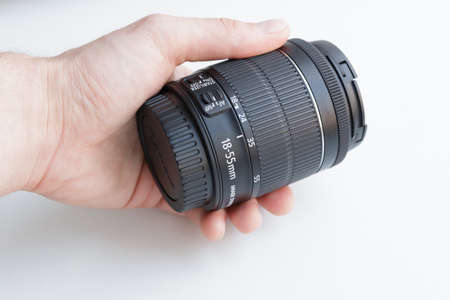 Hand holding camera lens on white backgroundの写真素材