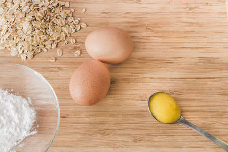 Raw oatmeal with ingredients honey and egg.の写真素材
