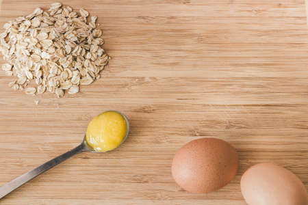 Raw oatmeal with ingredients honey and egg.の写真素材