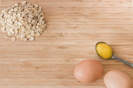 Raw oatmeal with ingredients honey and egg.の写真素材