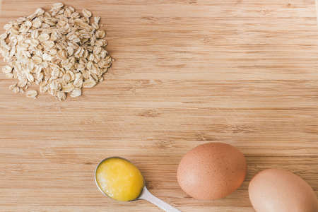 Raw oatmeal with ingredients honey and egg.の写真素材