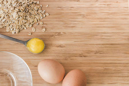 Raw oatmeal with ingredients honey and egg.の写真素材