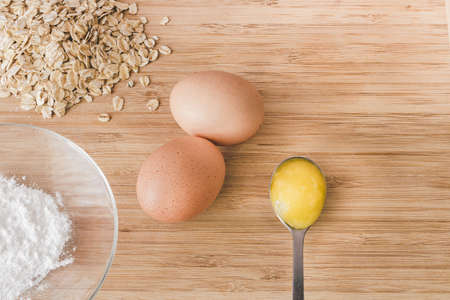 Raw oatmeal with ingredients honey and egg.の写真素材