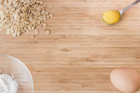 Raw oatmeal with ingredients honey and egg.の写真素材