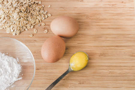 Raw oatmeal with ingredients honey and egg.の写真素材