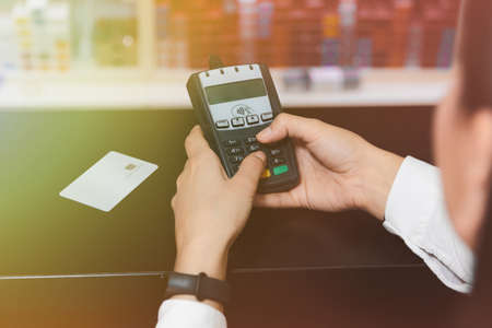 Close up hand of woman's hands inserting pin code on credit card terminal.の写真素材