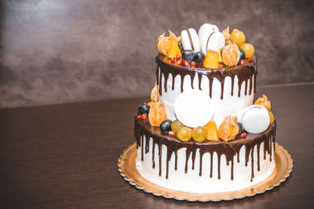 Delicious cake with fruit and berries decoration on wooden tableの写真素材