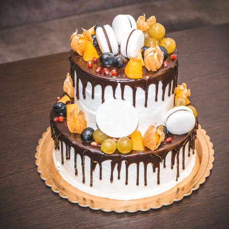 Delicious cake with fruit and berries decoration on wooden tableの写真素材