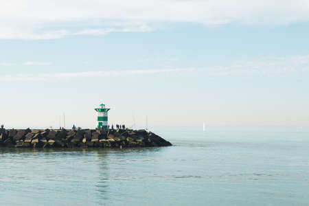 Lighthouse on the sea under sky in the Netherlandsの写真素材