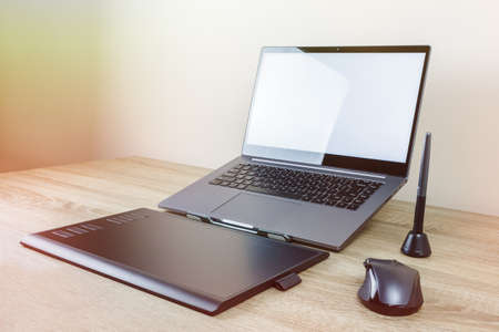 drawing tablet and laptop on wooden tableの写真素材