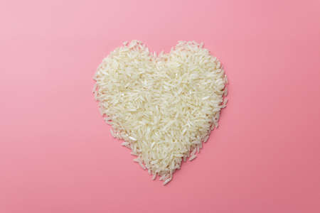rice grains in form of heart on a pink background, valentines dayの写真素材