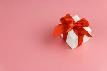 white gift box with red strap on colour background, engagement ring boxの写真素材