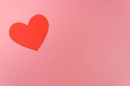 one red craft paper heart on pink background with copy spaceの写真素材