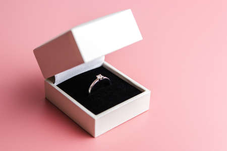 white engagement box with a white ring on a red background