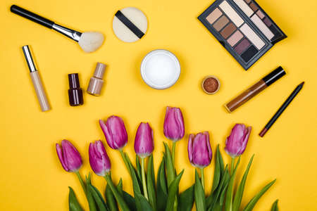 cosmetics and pink tulips on colour background, spring cosmetic for women