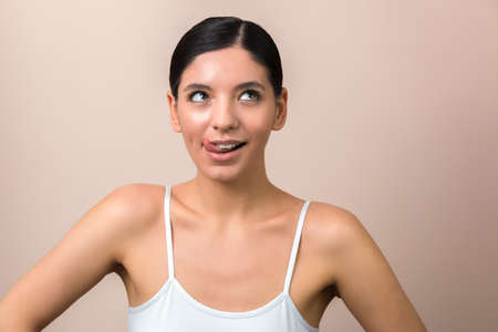 woman on diet thinking about food. girl with tongue out and eyes up scheming somethingの写真素材